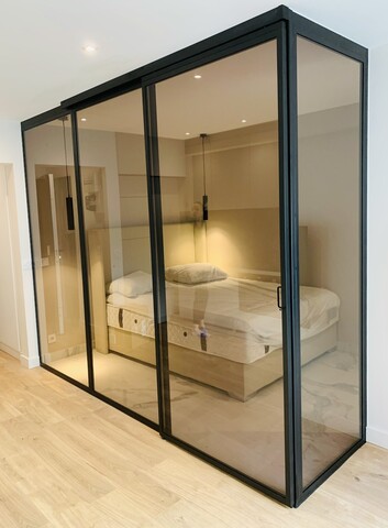 Porte coulissante verrière en verre bronze pour un espace chambre cocon à Paris 17
